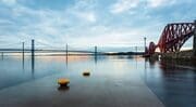 The tide washes over the Hawes Pier at South Queensferry with the Forth Bridges in the background, West Lothian, Scotland, United Kingdom. FB007