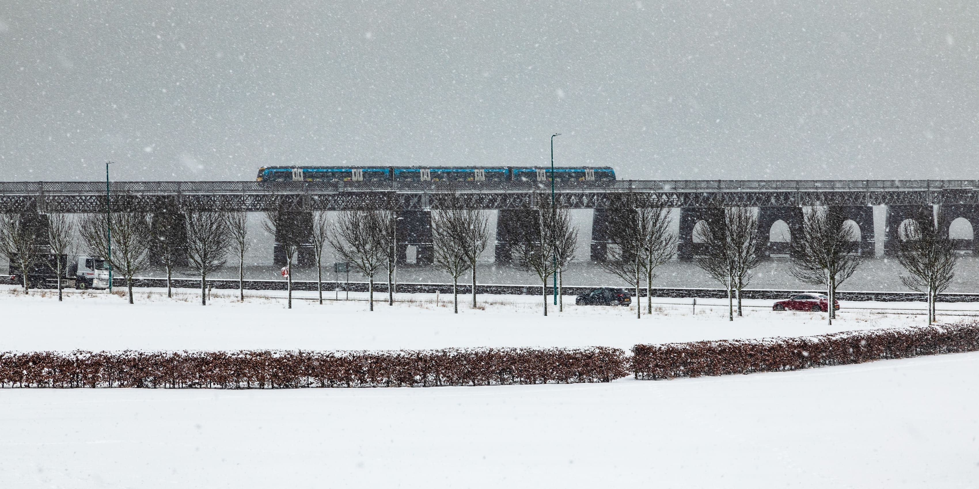 Train crossing the Tay Railway Bridge in a snowstorm, Dundee, Scotland