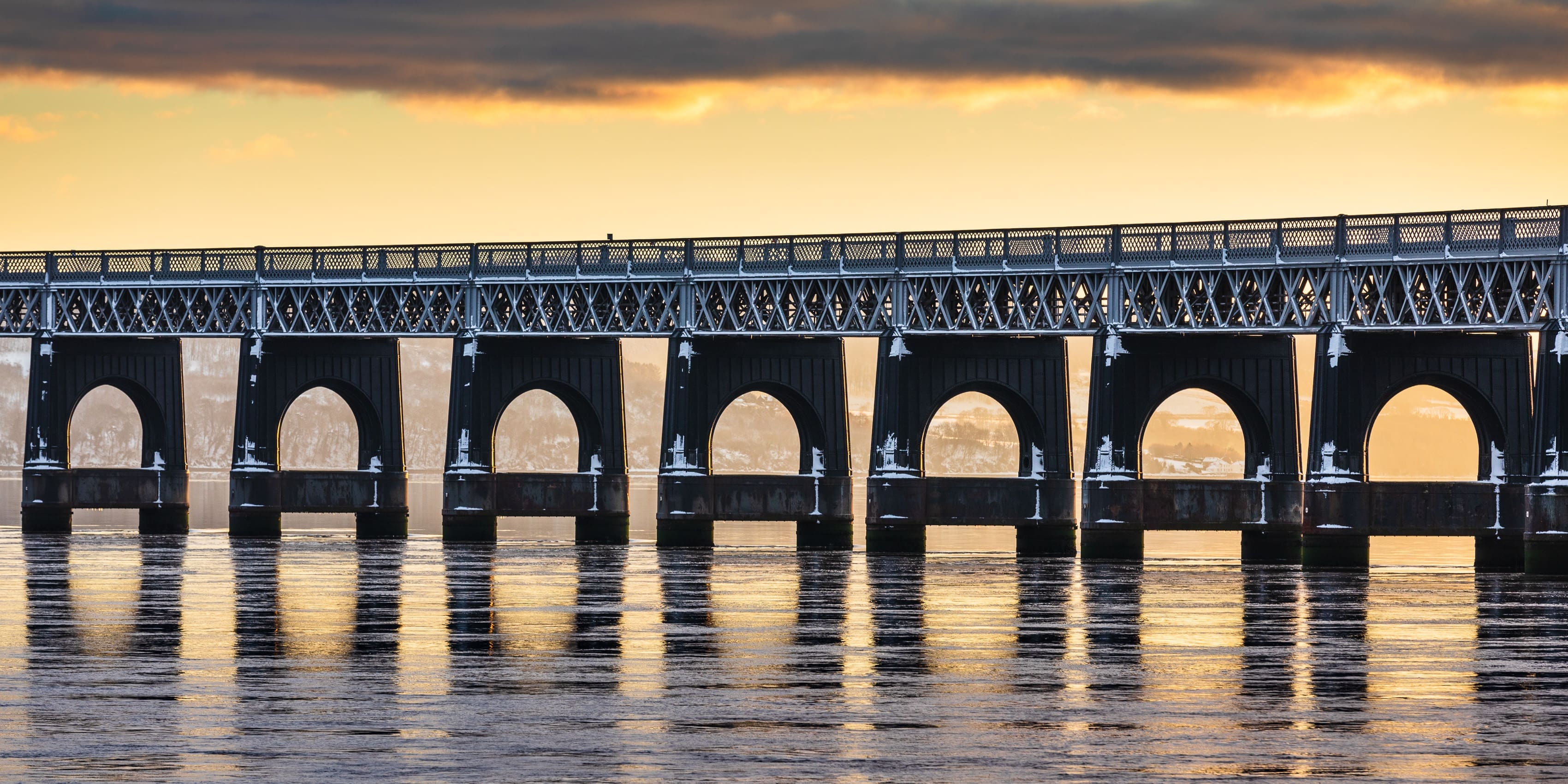 The Tay Railway Bridge backlit by a low winter sun, Dundee, Scotland.