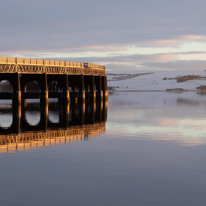 The Tay Railway Bridge lit by a low winter sun, Dundee, Scotland.