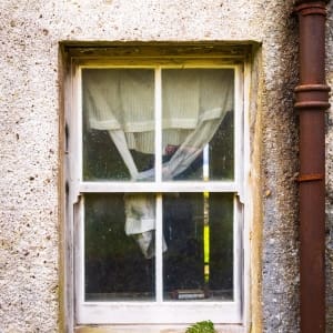 Curtained window of an abandoned croft house, near Callakille, Scotland. AP020