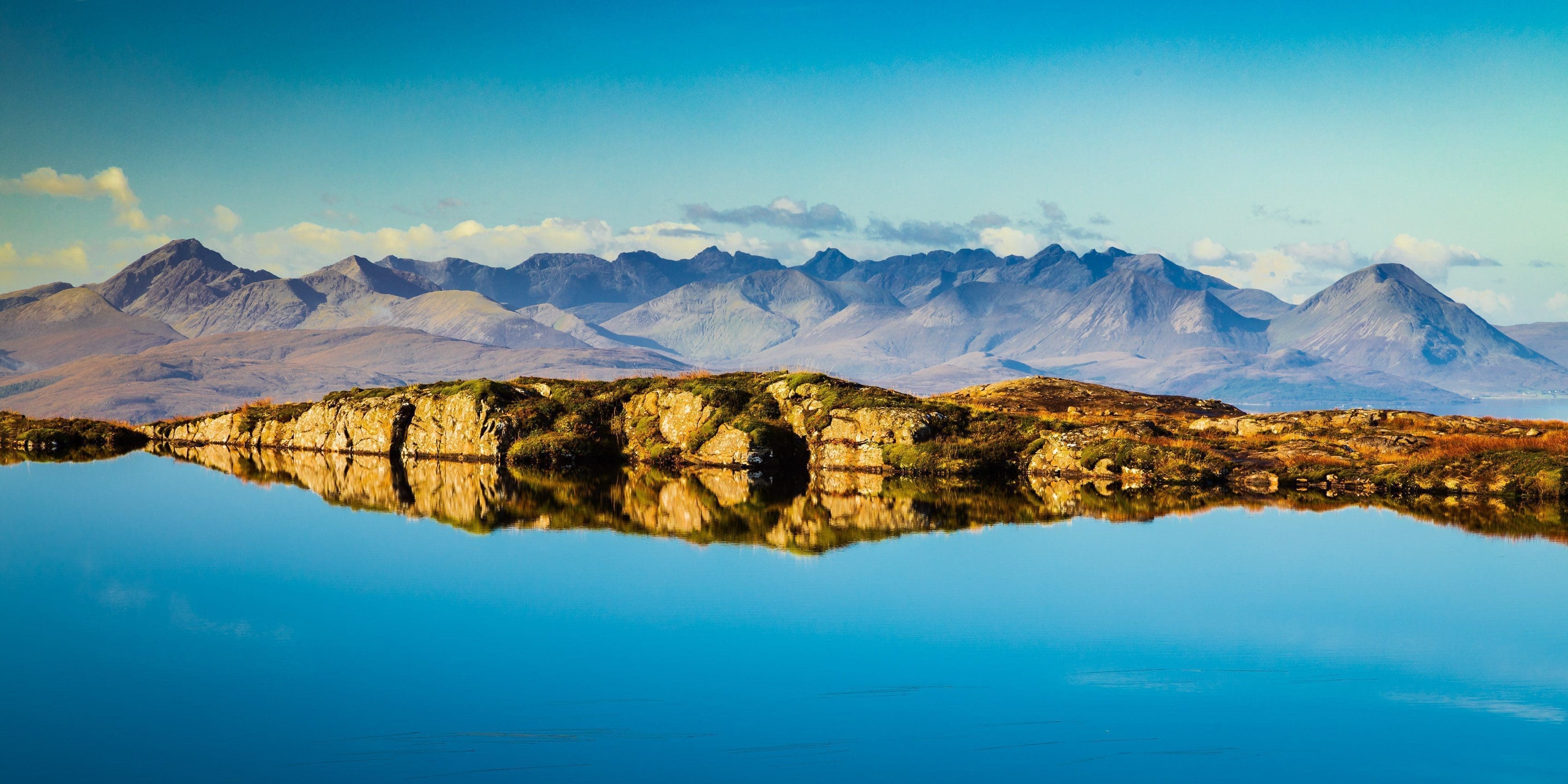 The Cuillins of Skye viewed from a lochan near the Bealach na Ba, Applecross, Scotland. AP014