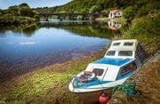 Cabin cruiser beached by the old quay on the River Blackwater at Cappoquin, County Waterford, Ireland. BW021