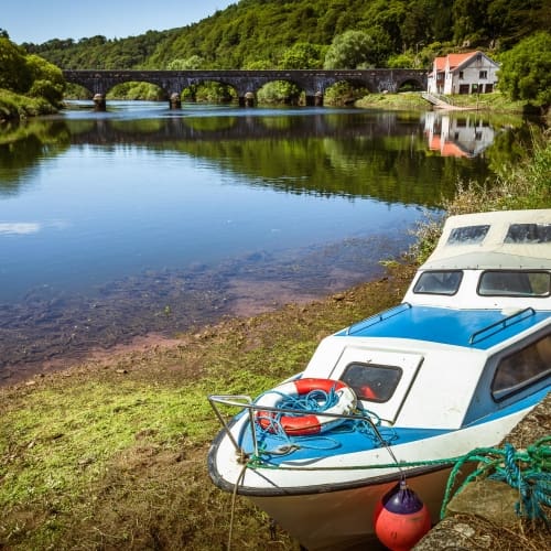 Cabin cruiser beached by the old quay on the River Blackwater at Cappoquin, County Waterford, Ireland. BW021