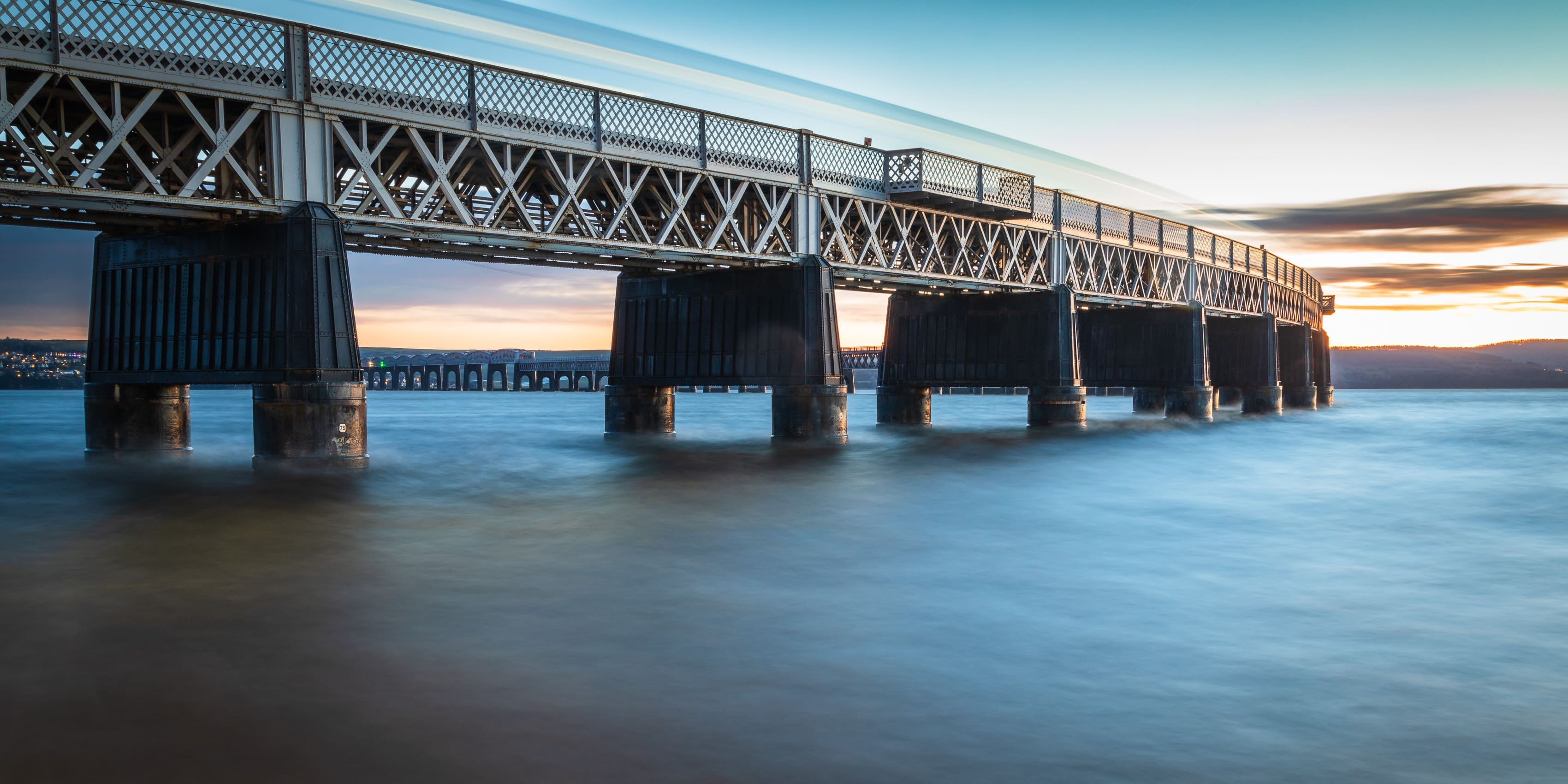 Long exposure as a train passes over the Tay Railway Bridge at high water.