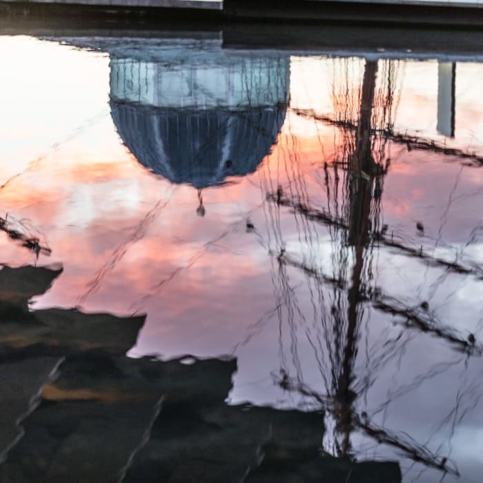 Reflections of the RRS Discovery, Discovery Centre and V&amp;A Dundee in pool outside the V&amp;A Dundee building.